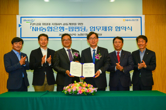 29일 서울 중구 농협은행 신관에서 열린 'P2P금융 외담대 지원API 개발 위한 업무협약식에서 신현욱 팝펀딩 대표이사(왼쪽에서 세번째)와 이대훈 농협은행장(네번째)이 기념촬영을 하고 있다.   NH농협은행 제공